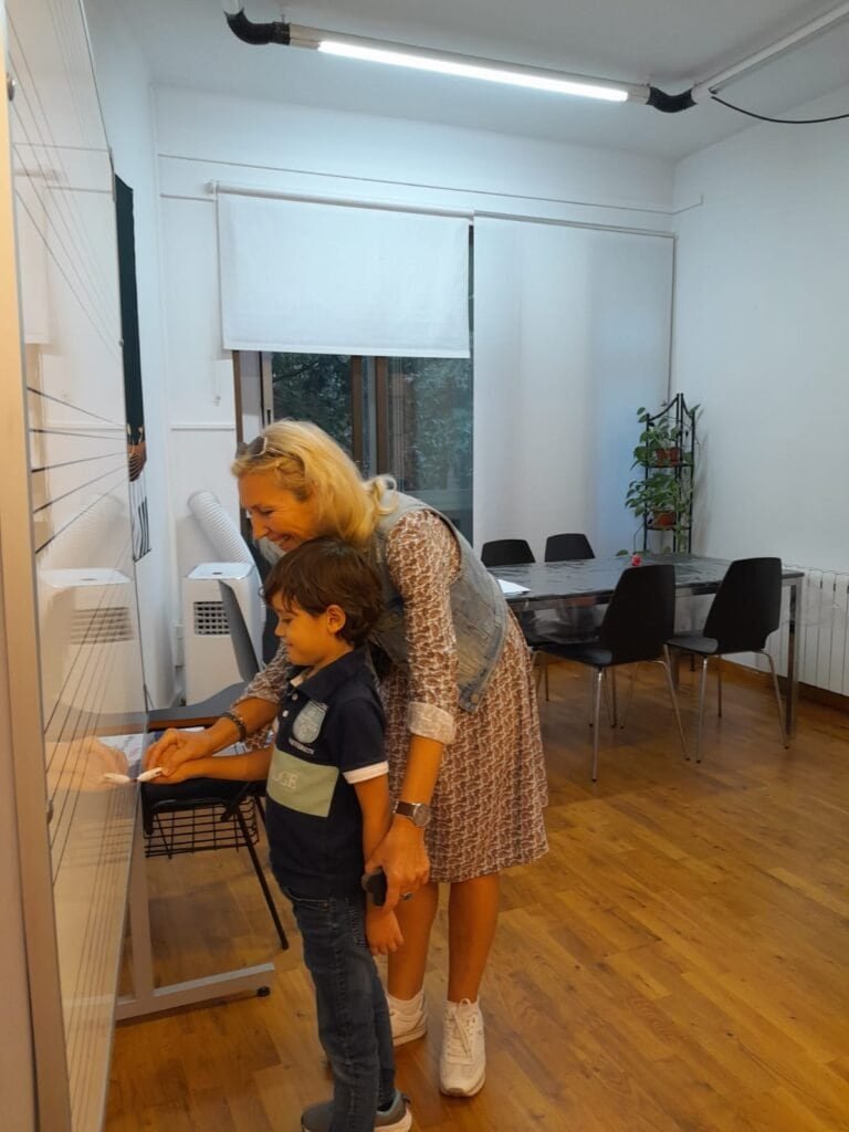 Niña y profesora en clase de piano en centro cultural.