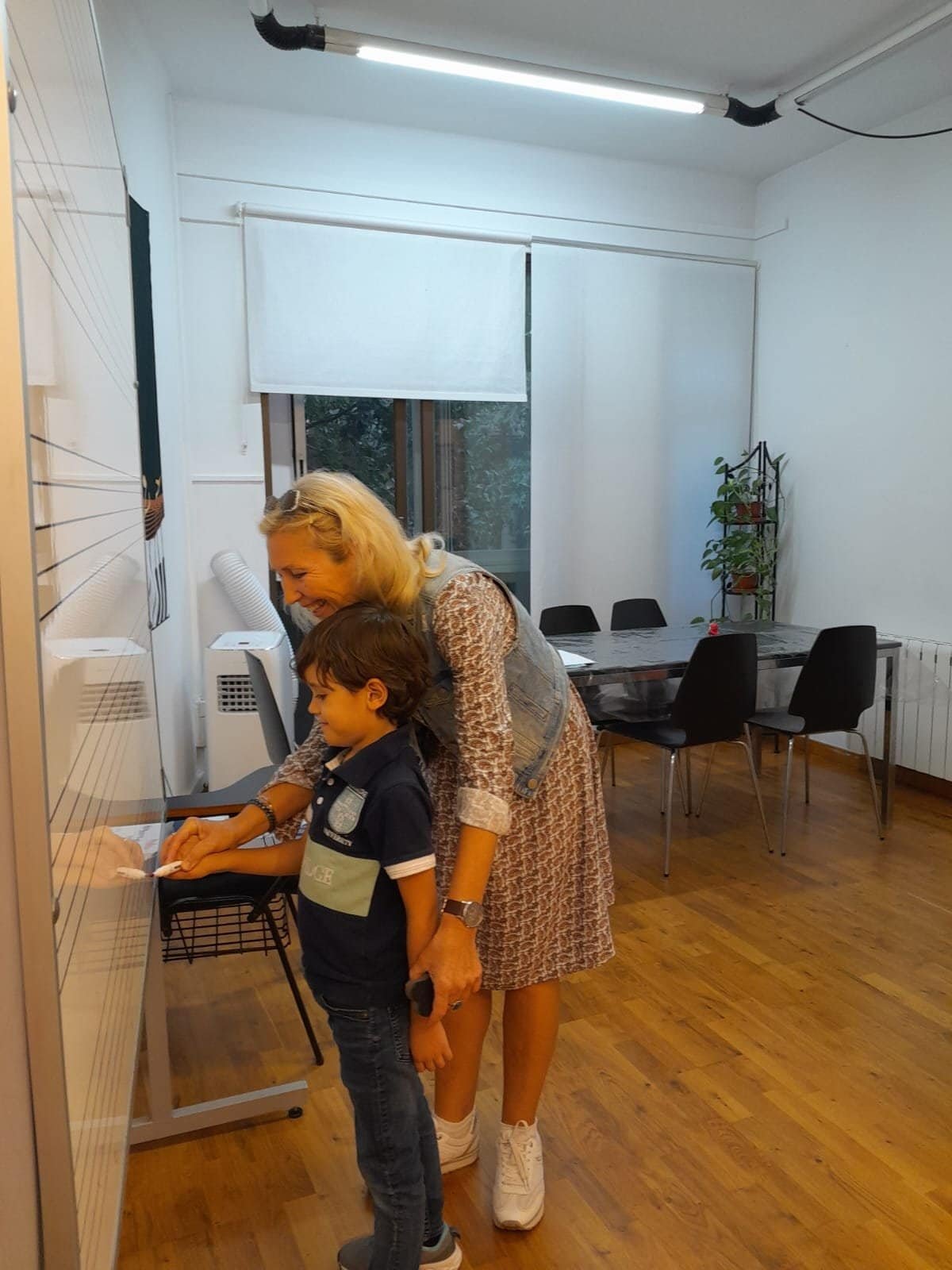Niña y profesora en clase de piano en centro cultural.