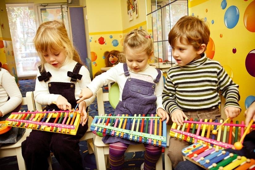 Children playing xylophones in a music workshop at a cultural centre.