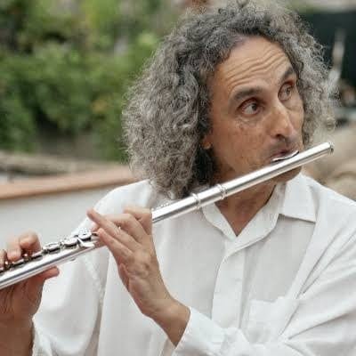 Man playing the flute in an outdoor setting.